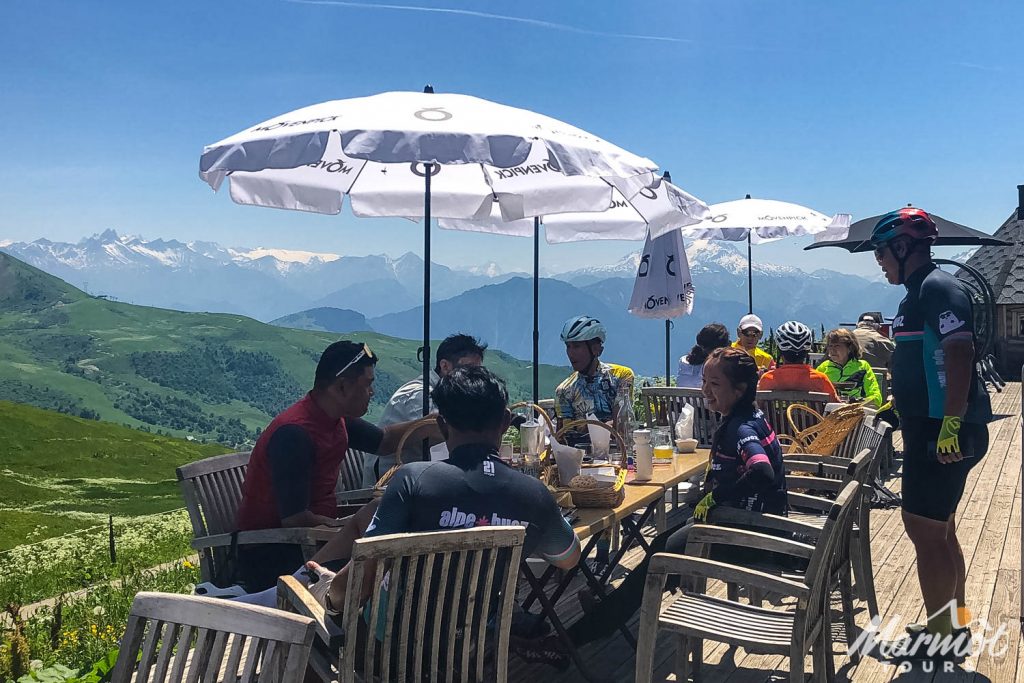 Cyclist at cafe on Col de la Madeleine with Marmot Tours road cycling holiday Alps