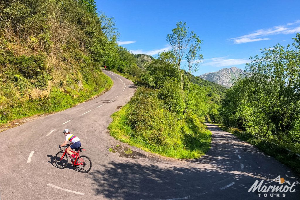 Cyclist climbing alto de l'angliru with Marmot Tours