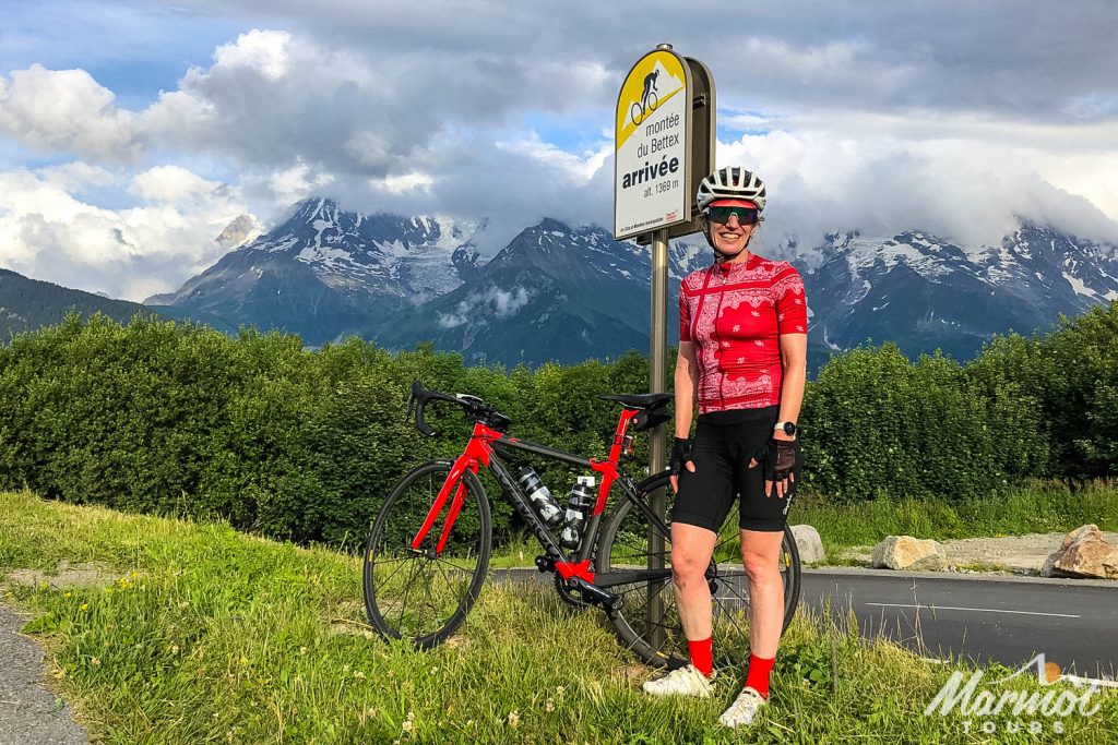 Cyclist smiling at Monte de Bettex on Tour de France 2023 challenge with Marmot Tours