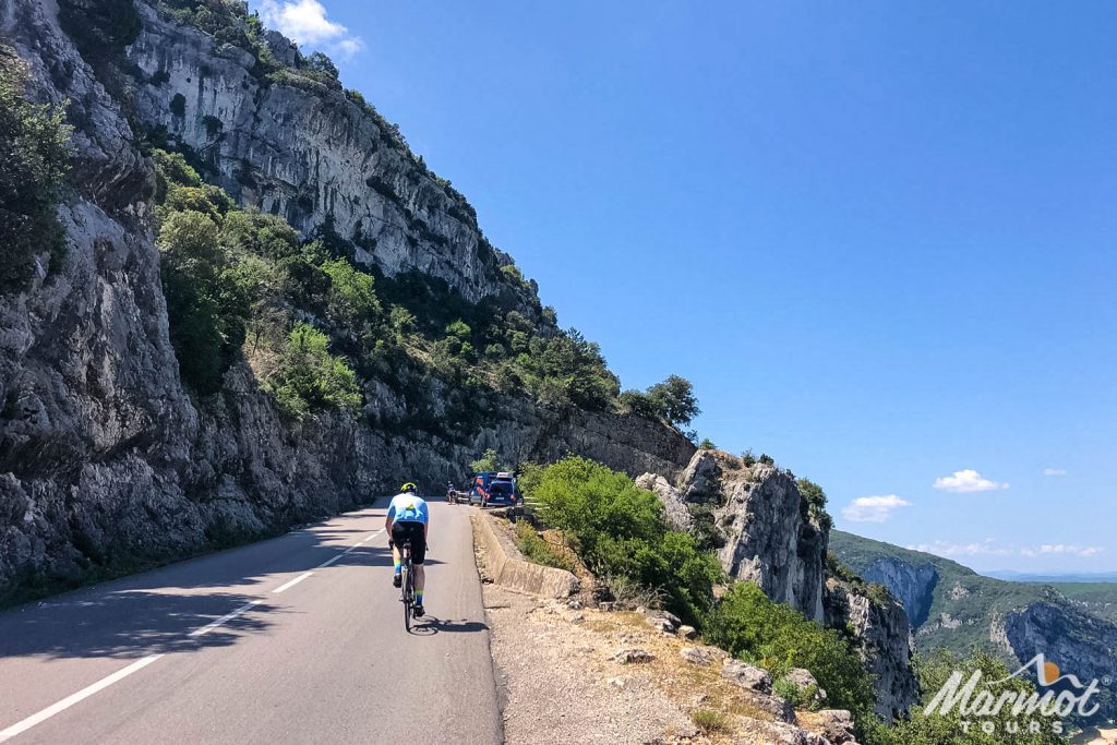 Cyclist climbing towards Marmot Tours support vehicle on cycling tour of southern france