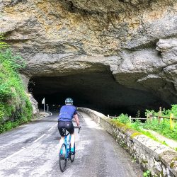 Cyclist entering cave on guided cycling tour foothills Pyrenees with Marmot Tours