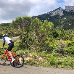 cyclist rounding hairpin in foothills of pyrenees with Marmot Tours