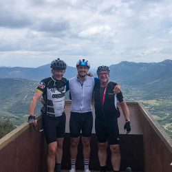 three cyclists smiling at viewpoint in foothills pyrenees with marmot tours