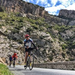 cyclists riding through gorge in foothills pyrenees with marmot tours