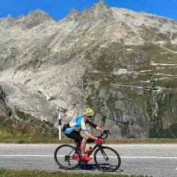 Cyclist climbing grimsel and furka passes Swiss Alps on Marmot Tours Raid Dolomites road cycling challenge