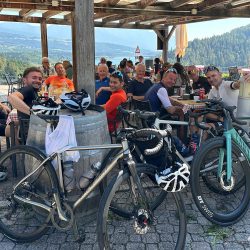 Group of cyclist enjoying rest stop at cafe on Marmot Tours guided road cycling holiday Italian Dolomites