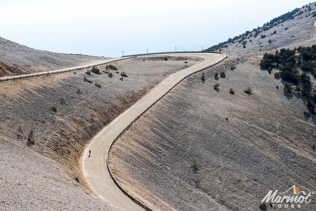 Cyclist descending Mont Ventoux surrounded by limestone mountainside on Marmot Tours guided road cycling holiday