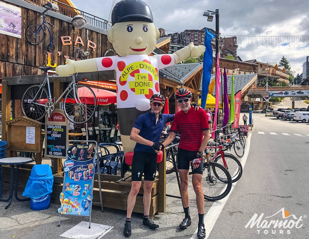 Pair of cyclists celebrating at Alpe d'Huez cycling climb with Marmot Tours guided road cycling holidays