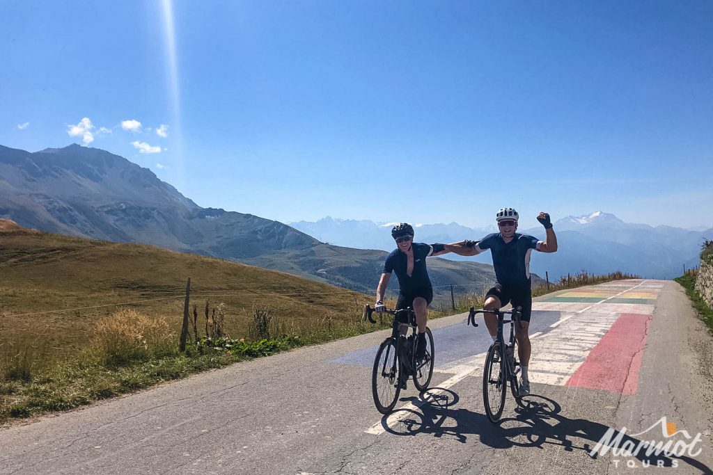 Pair of cyclists Summiting Col de la Madeleine on Marmot Tours guided road cycling holiday in French Alps