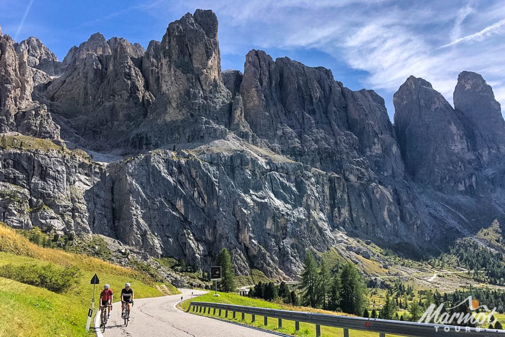 Pair of cyclist climbing in towering Italian Dolomites on Marmot Tours guided road cycling holidays