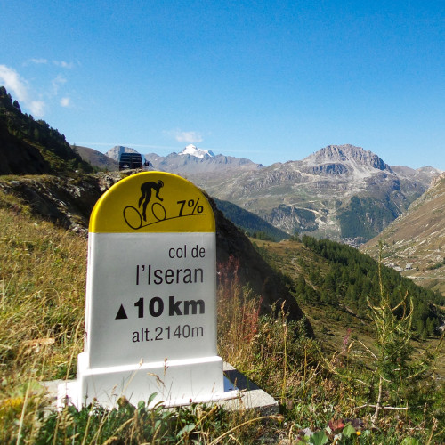 view from col de l'iseran showing cycling road marker and val d'isere below on marmot tours French alps cycling holiday
