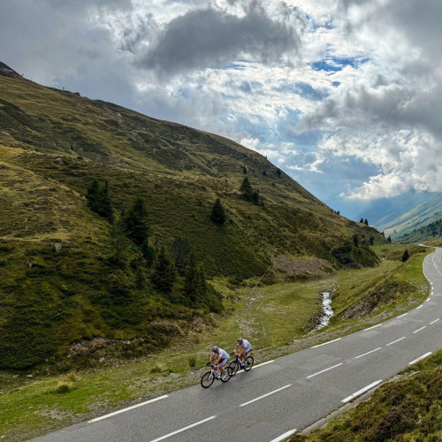 pair of cyclists climb col du Tourmalet through valley on raid pyrenees cycling challenge with marmot tours