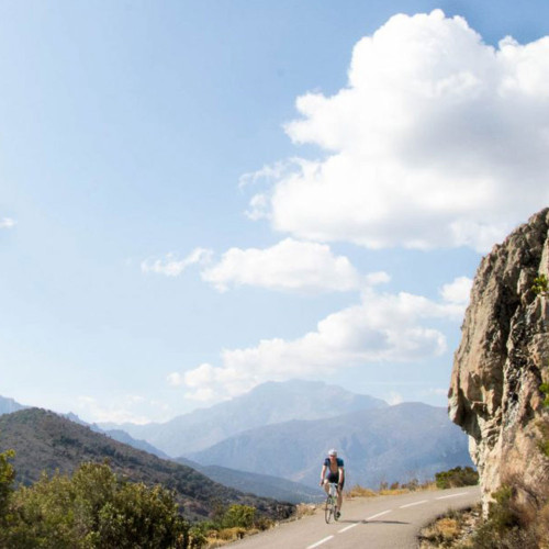 Cyclist enjoying climb on Col de Bigorno on guided road cycling tour of Corsica with Marmot Tours