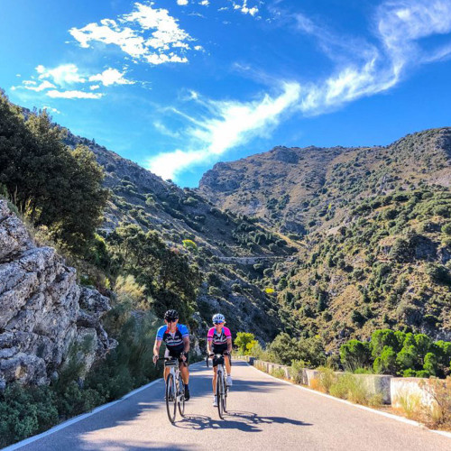 Two cyclists in sunshine of Sierra de Grazalema on guided road cycling tour of Andalusia Spain with Marmot Tours
