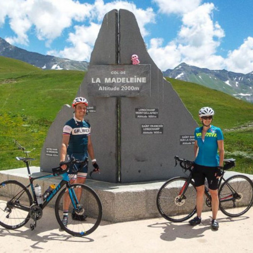 A male and female cyclist at the top of Col de la Madeleine French Alps