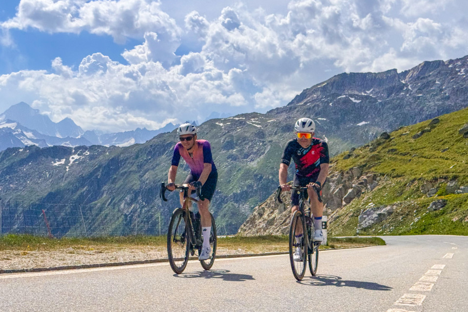 pair of cyclists climbing Furkapass with Swiss alps backdrop on marmot tours cycling holiday