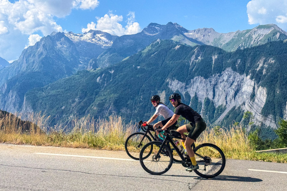 pair of female cyclists climb Alpe d'hued in French alps on marmot tours guided group cycling holiday