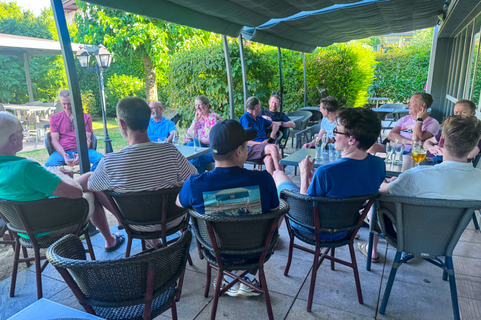 group of cyclists chatting seated on hotel terrace on marmot tours guided road cycling tour pyrenees Atlantic to mediterranean