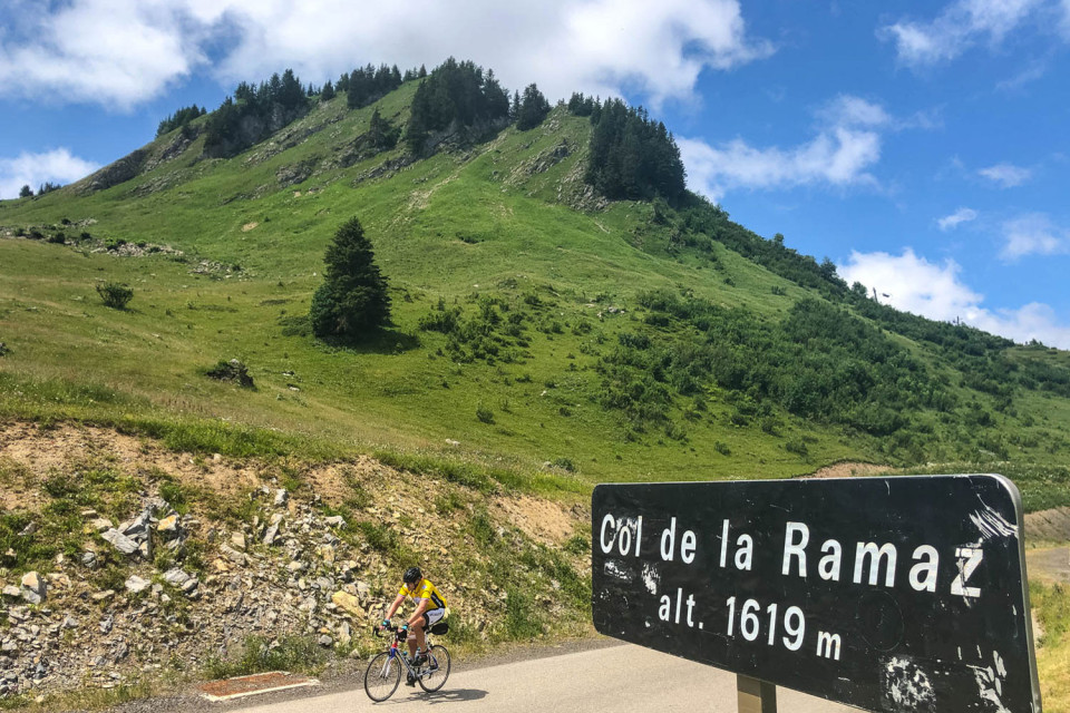 Cyclist summiting Col de la Ramaz with blue sky on Marmot Tours guided road cycling tour Northern French Alps