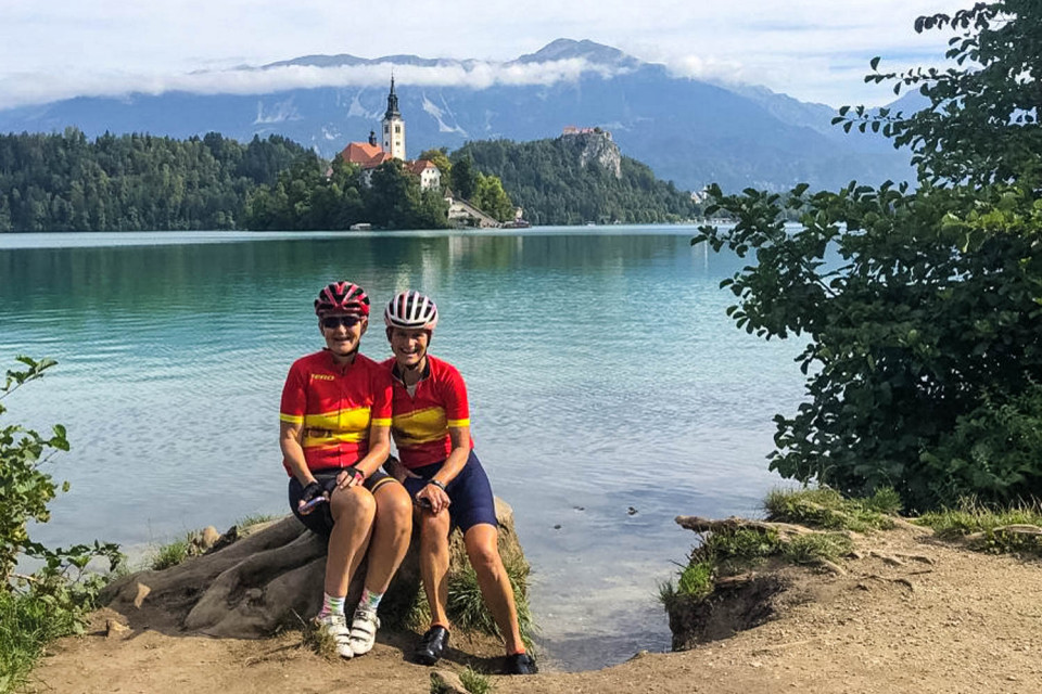 Pair of female cyclists hose for photo on shore of Lake Bled on Slovenia cycling holiday with Marmot Tours