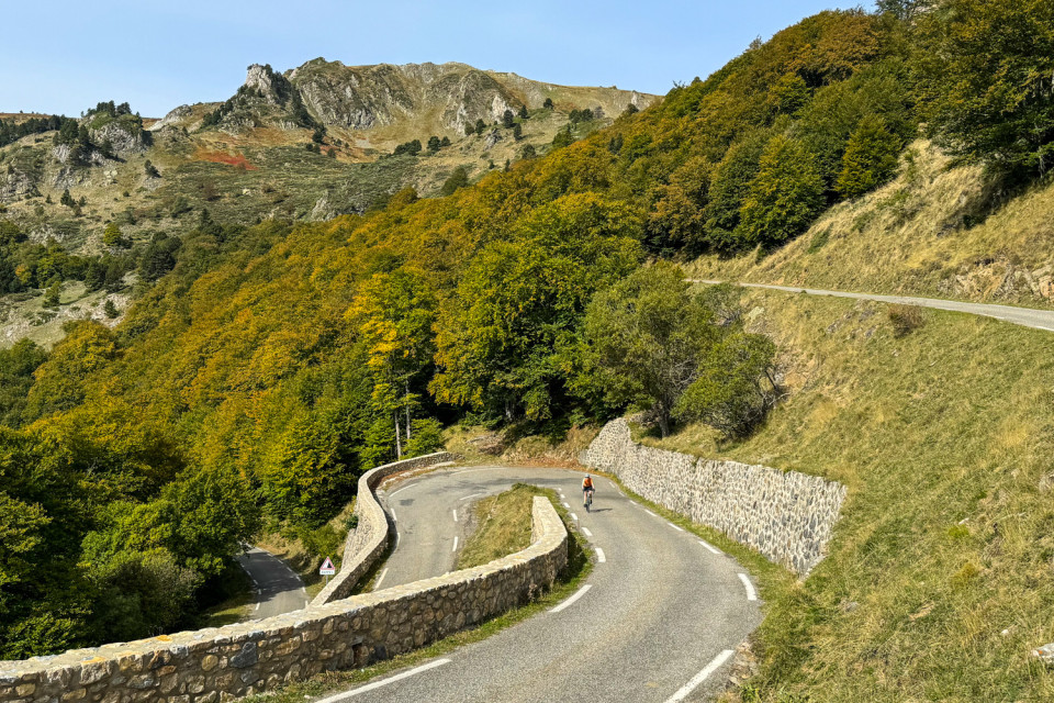 cyclist climbing snaking mountain pass on cycling holiday in pyrenean foothills with marmot tours