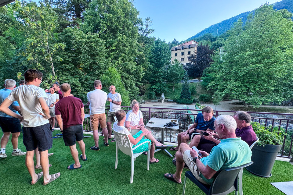 group of cyclists gather on hotel terrace on French Pyrenees cycling holiday with marmot tours