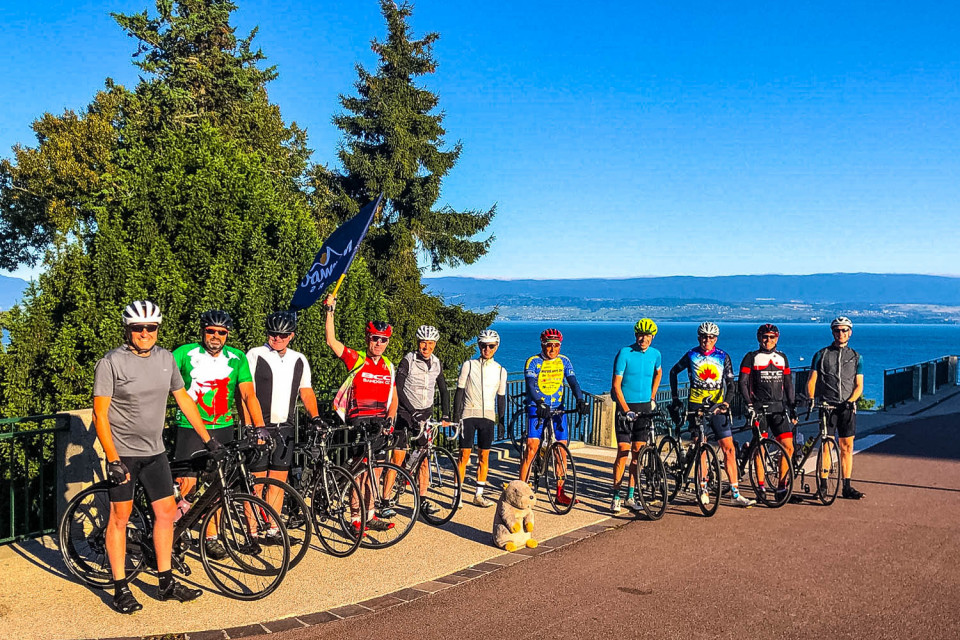 Group of cyclists with Lake Geneva in background on Marmot Tours guided road cycling tour Northern French Alps