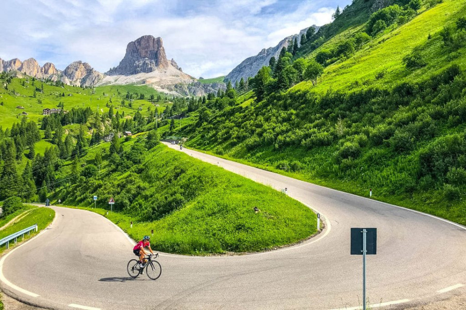 Cyclist climbing hairpin bend on full support cycling mini break Dolomites Italy with Marmot Tours