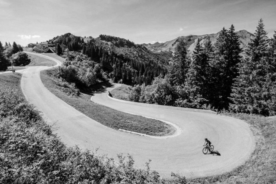 Black and white image of cyclist on road to roux plane on Marmot Tours guided road cycling tour French Alps