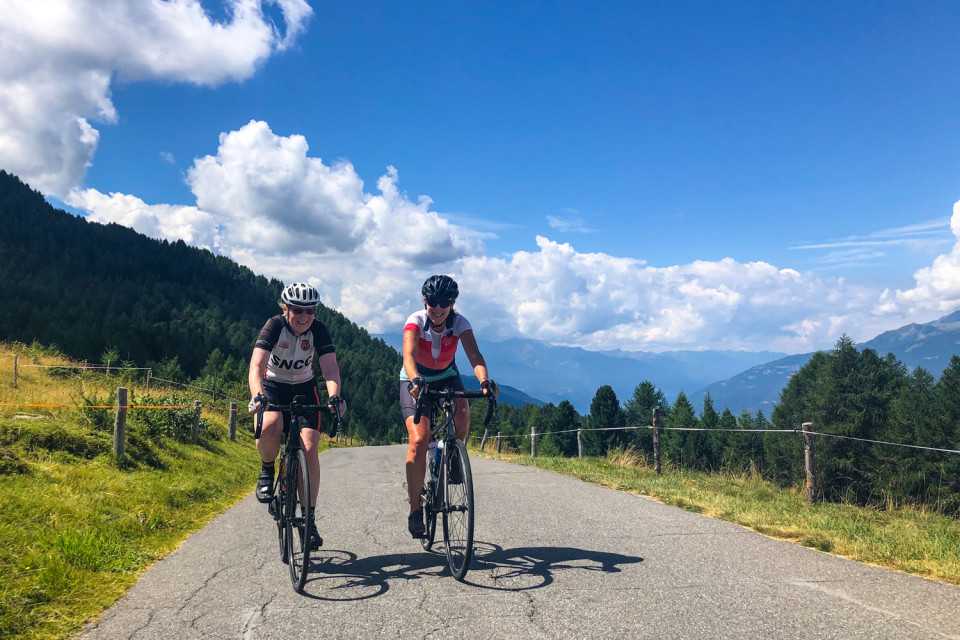 two female cyclists summiting Passo Mortirolo on marmot tours guided road cycling tour Italy