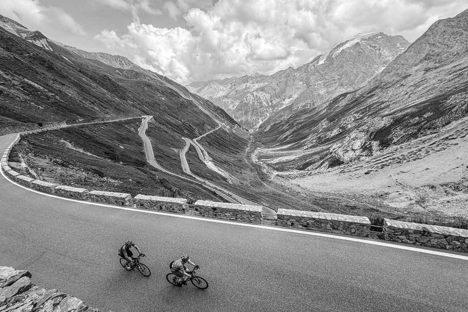 Black and white image of pair of cyclists climbing Passo dello Stelvio on Marmot Tours full support cycling holiday