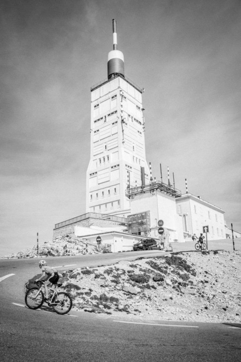 Black and white image of beacon and cyclist on summit of Mont Ventoux on Marmot Tours road cycling challenge