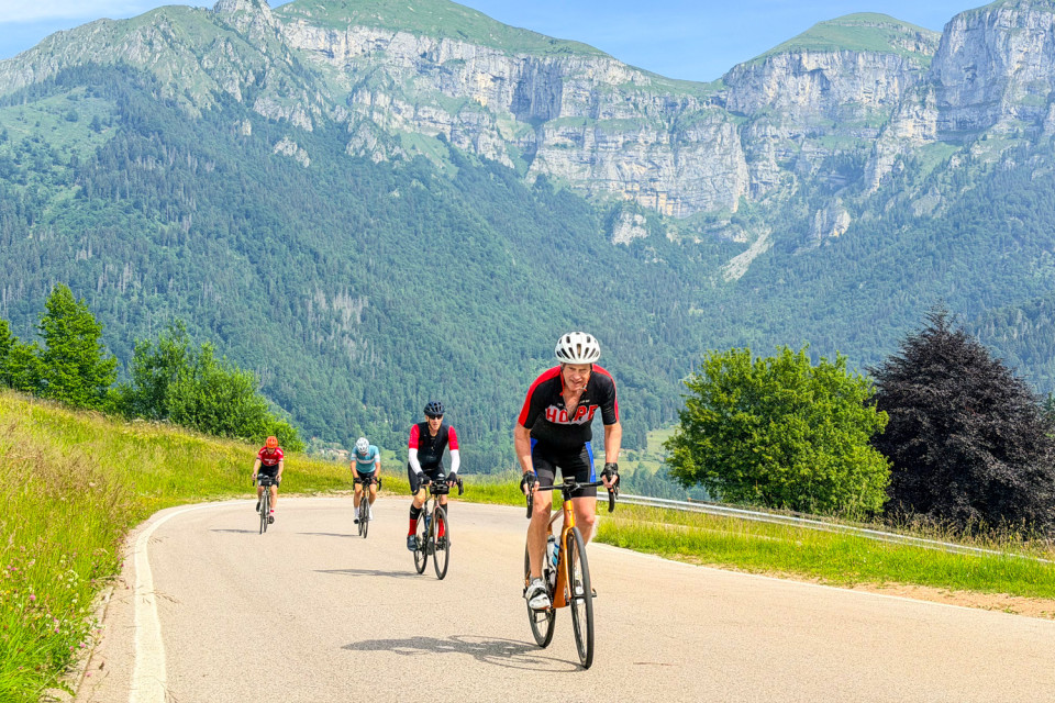 Group of cyclists climbing mountain pass on monetary grappa cycling holiday southern dolomites mountain peaks background with marmot tours