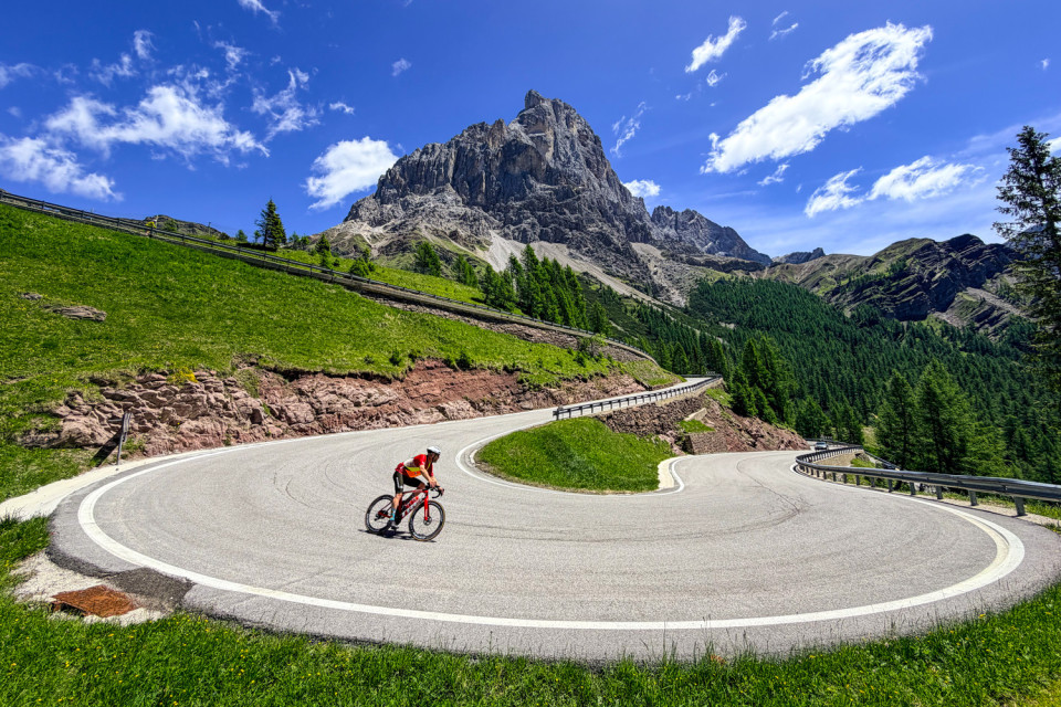 Cyclist descending on hairpin ben on monte grappa southern dolomites cycling holiday with marmot tours