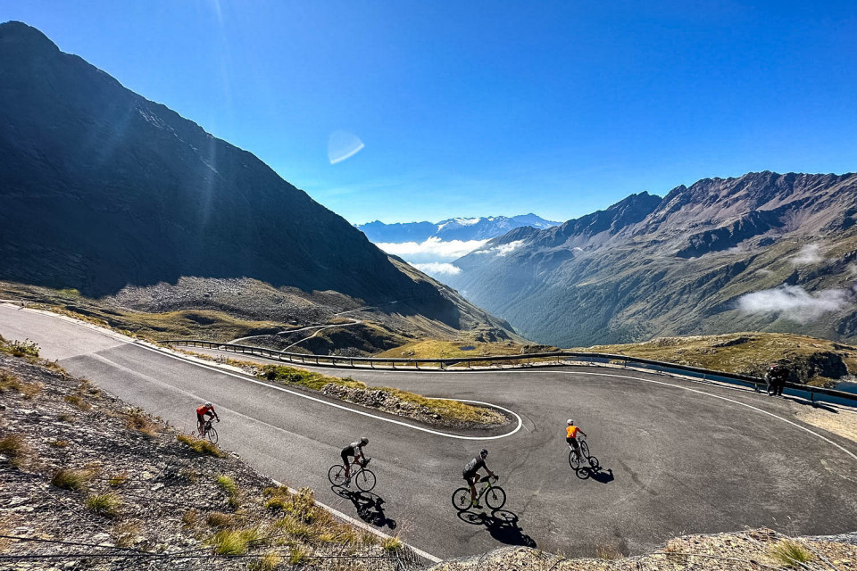 Cyclists descending hairpin on Passo di Gavia cycling climb on Raid Dolomites cycling challenge with Marmot Tours