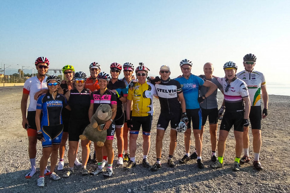Group of cyclists pose for photo on beach at Nice on Marmot Tours guided Raid Alpine challenge