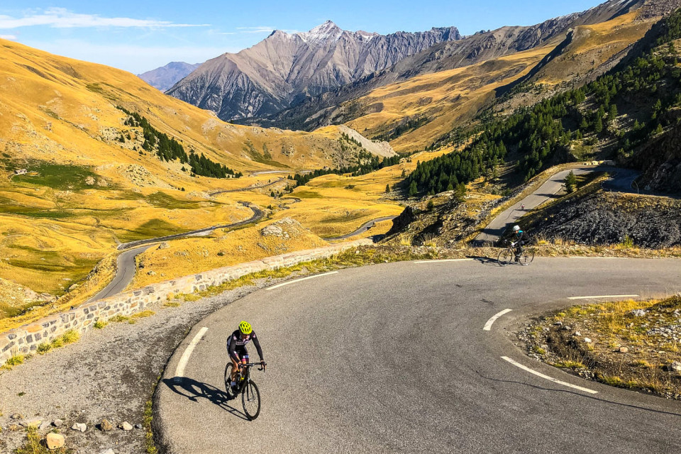 Cyclists climbing come de la bonette on raid alpine challenge with marmot tours
