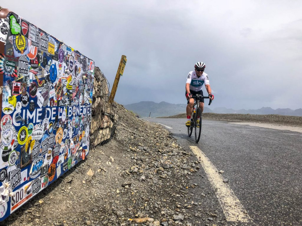 Cyclist summiting Cime de la Bonette on Raid Alpine with Marmot Tours road cycling holidays