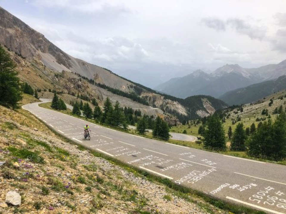 Cyclist climbing Col d'Izoard on Raid Alpine Marmot Tours