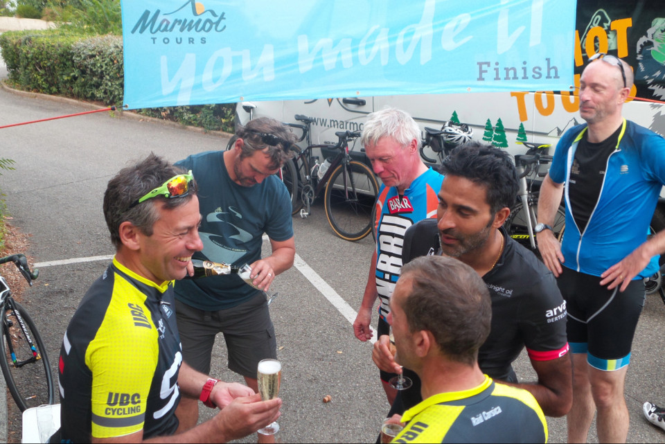 cyclists celebrate completion of raid corsica challenge with marmot tours with champagne