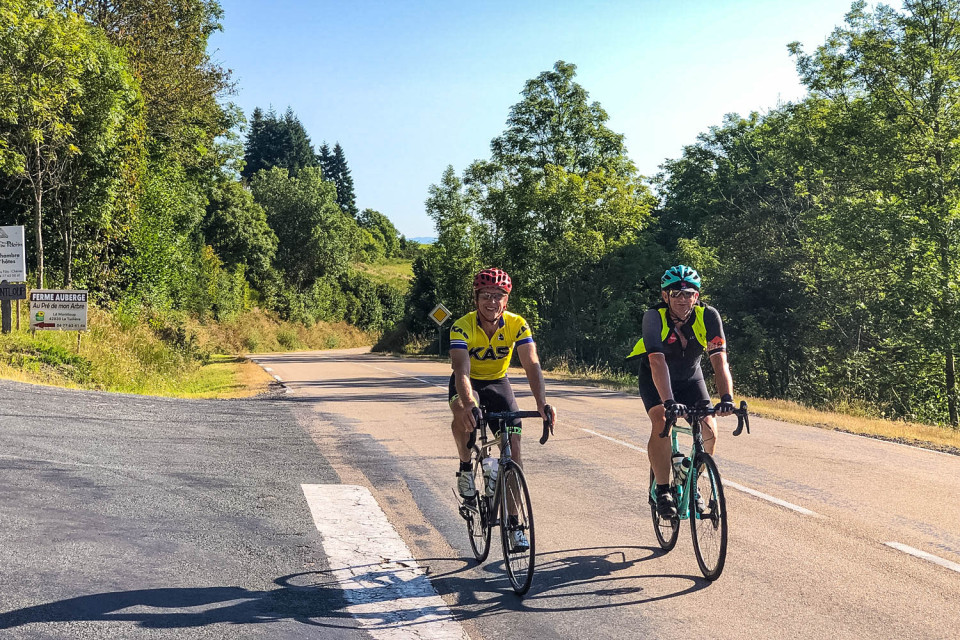 pair of cyclists climbing col du beal on raid du Massif Central cycling challenge with marmot tours