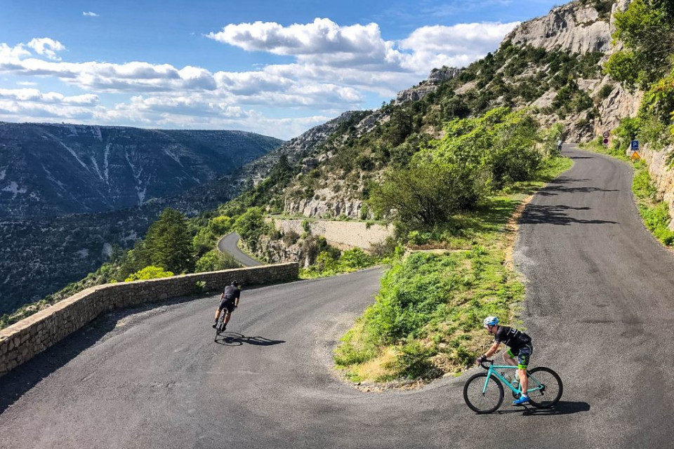 Pair of cyclists descending Cirque de Vavacelles on Marmot Tours Raid Massif Central French cycling holiday