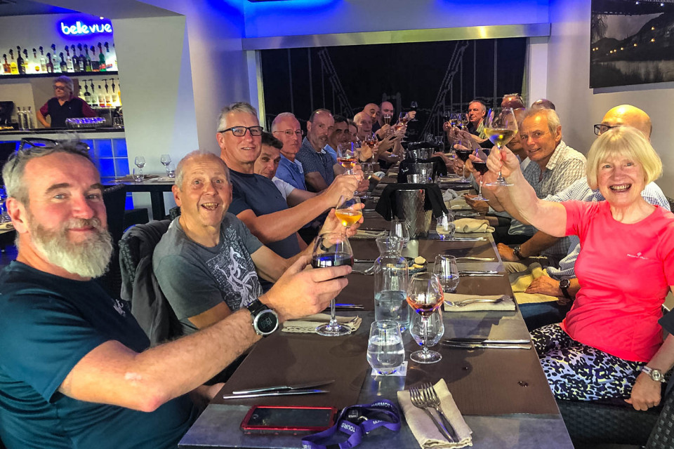 Group of cyclist raise glasses in restaurant on Marmot Tours guided road cycling holiday south of France