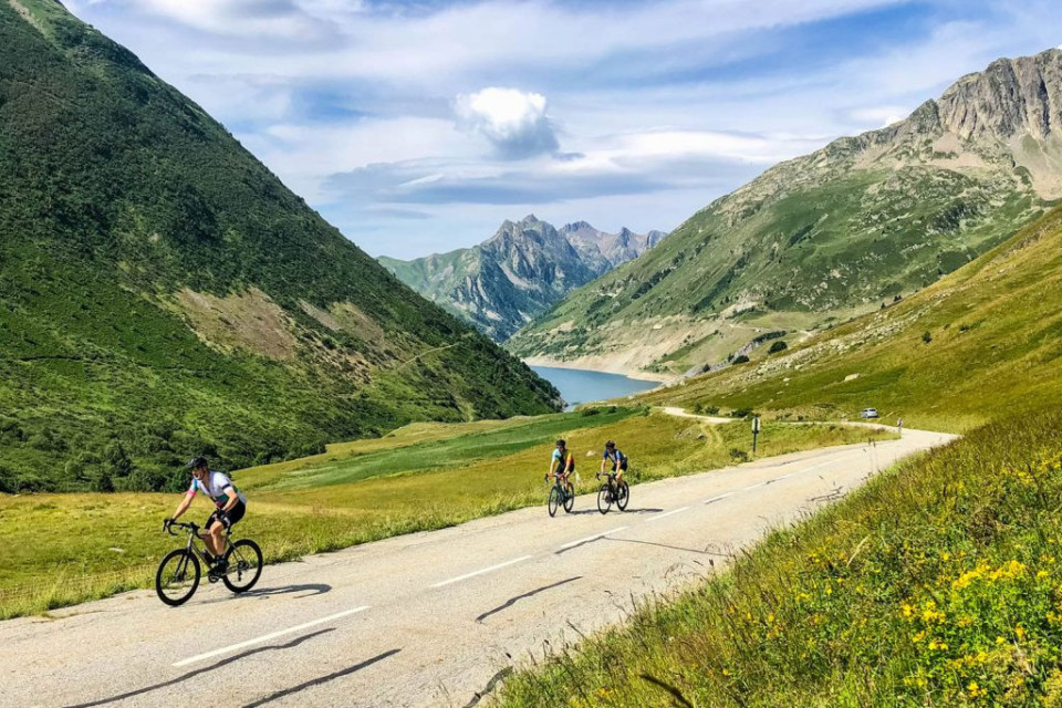 Group of cyclists enjoying climbing in French Alps on guided cycling tour with Marmot Tours