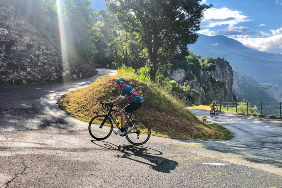 Cyclists rounding hairpin bend on guided cycling holiday French Alps with Marmot Tours