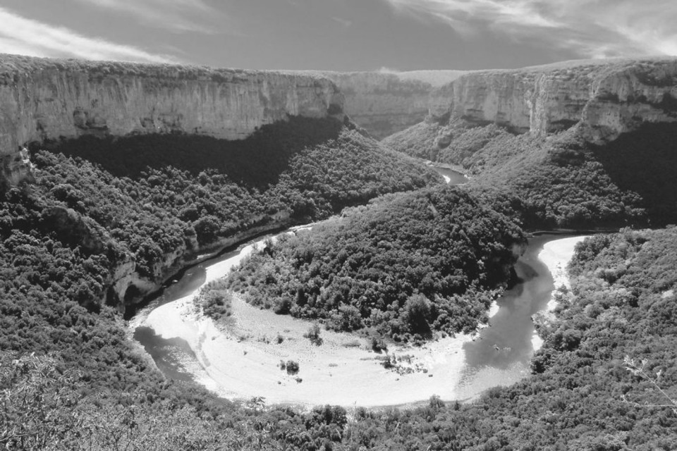 Black and white image of bend on river Ardeche through gorge on Marmot Tours road cycling holiday in South of France