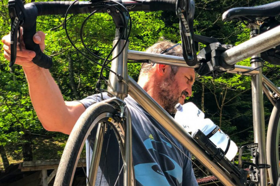 Marmot Tours guide performing bike maintenance on guided road cycling tour Europe