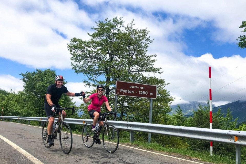 Pair of cyclists celebrating at Puerto del Ponton in Picos Northern Spain with Marmot Tours
