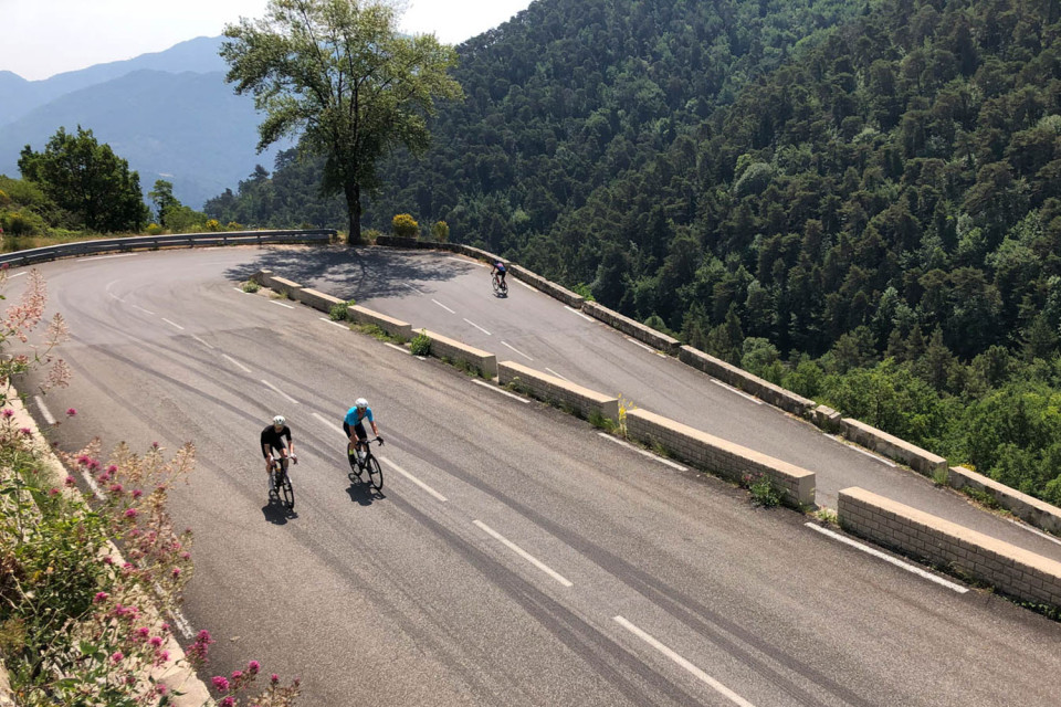 cyclists climbing mountain pass with tight hairpin bends on southern French alps cycling holiday with marmot tours