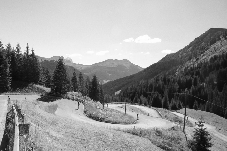 Cyclists climbing hairpin bends on mountains of Dolomites on Marmot Tours guided road cycling tour Dolomites Italy